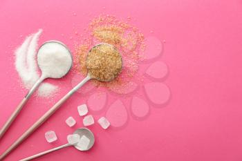 Spoons with sweet sugar on color background�