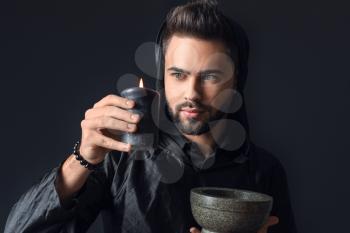 Male magician on dark background�