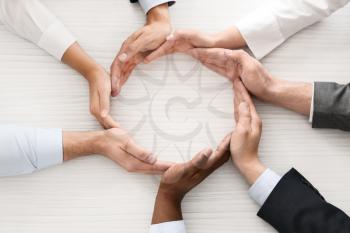 Group of business people making circle with their hands in office, top view. Unity concept�