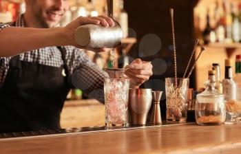 Bartender making cocktail in pub�