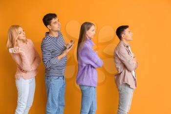 Young people waiting in line on color background�