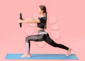 Sporty young woman training against color background�