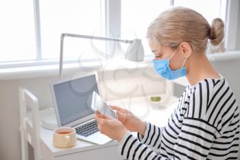 Sick woman with tablet computer at home�