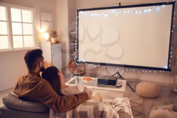 Young couple watching movie at home�