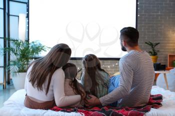 Young family watching movie at home�