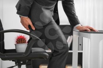 Young man suffering from hemorrhoids in office�