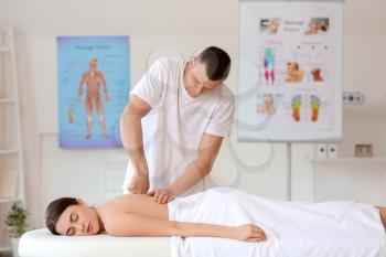 Massage therapist working with female patient in medical center�
