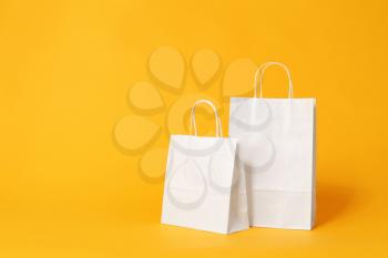 Paper shopping bags on color background�