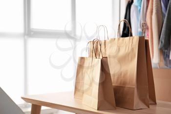 Many paper shopping bags on table in room�