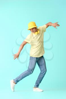 African-American teenager dancing against color background�