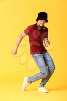 African-American teenager dancing against color background�