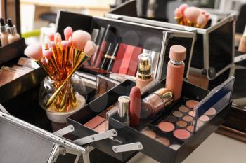 Case of professional makeup artist with decorative cosmetics on table�