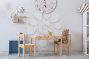 Stylish interior of children's room with table and chairs�