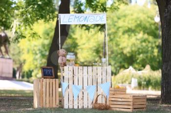 Wooden lemonade stand in park on sunny summer day�