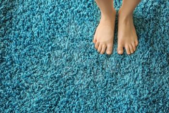 Barefoot girl standing on carpet�