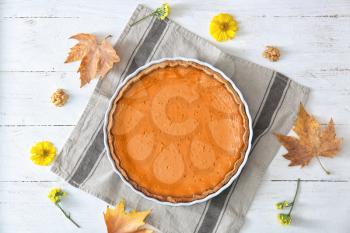 Baking dish with tasty pumpkin pie on white wooden table, top view�