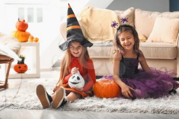 Cute little girls in Halloween costumes at home�