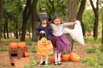 Cute little girls dressed for Halloween having fun in autumn park�