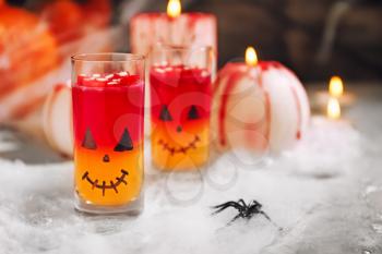 Creative glasses with drink prepared for Halloween party on table�