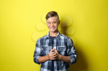 Smiling teenage boy on color background�