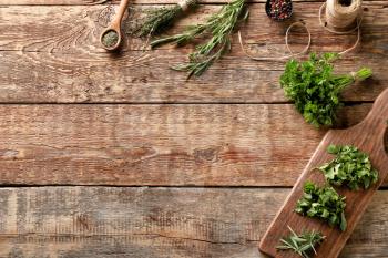 Different fresh herbs with spices on wooden background�