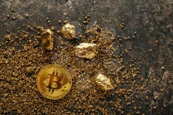 Bitcoin and gold nuggets on grey background�