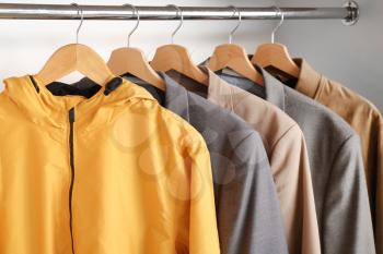 Stylish male clothes on hanger in wardrobe�