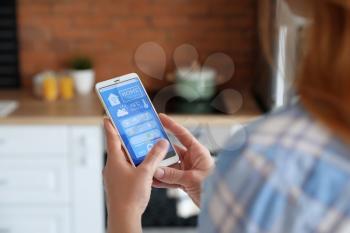 Woman using application of smart home automation�
