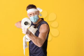 Funny man with toy gun and toilet paper on color background. Concept of coronavirus epidemic�