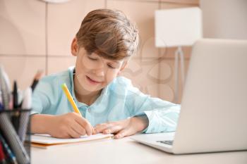 Cute little boy studying at home. Concept of online education�
