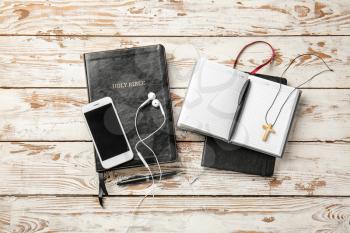 Composition with Holy Bible and mobile phone on wooden background�