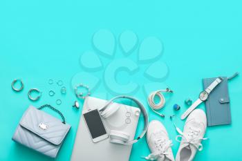 Female accessories with laptop, headphones and mobile phone on color background�