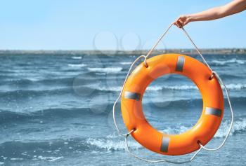 Woman with lifebuoy ring near river�