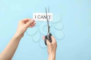 Woman with scissors turning phrase I CAN'T to I CAN on color background�