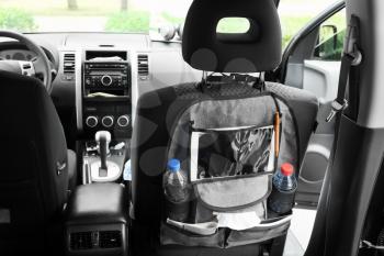 Travel organizer with different things on car seat in salon�