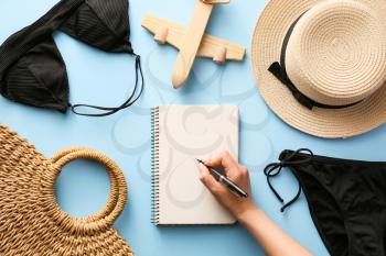 Woman making check-list of things to pack for travel�