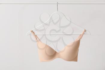 Hanger with stylish bra on light background�