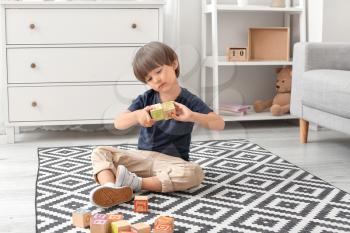 Little boy with autistic disorder playing with cubes at home�