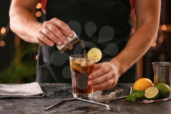 Barman making Cuba Libre cocktail with lime and ice�