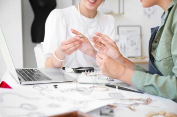 Female jewelry designers with adornment in office�