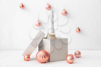 New Year composition with bottle of champagne on light background�