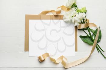 Composition with blank card and flowers on white wooden background�