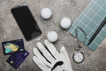 Credit cards, mobile phone and golf glove on grunge background. Concept of sports bet�
