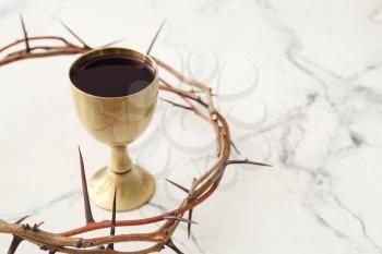 Chalice of wine and crown of thorns on white background�