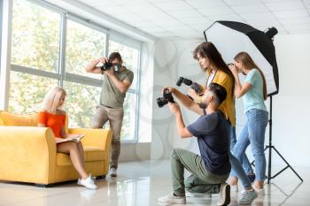 Young photographers taking picture of woman in studio�