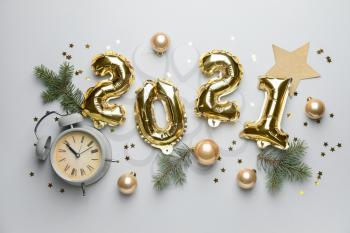 New Year composition with alarm clock and figure 2021 on light background�