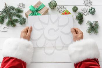 Santa Claus with empty letter at table�