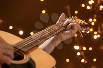 Man playing guitar on Christmas eve, closeup�