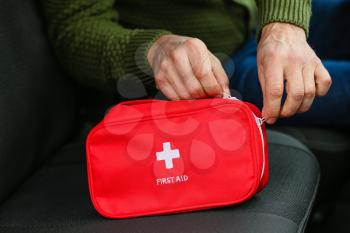 Man with first aid kit in car, closeup�