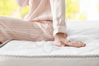 Woman sitting on soft orthopedic mattress, closeup�